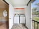 Enclosed outdoor laundry area with washer, dryer, and shelving for extra storage at 110 W Cypress Ct, Oldsmar, FL 34677