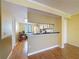 Open floor plan with hardwood flooring leading to eat-in kitchen and entry doorway at 110 W Cypress Ct, Oldsmar, FL 34677