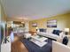 Bright living room featuring hardwood floors, modern decor, and an open floor plan leading to the dining area at 110 W Cypress Ct, Oldsmar, FL 34677