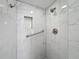 Modern shower featuring white marbled tile, a built-in niche, and sleek fixtures at 110 W Cypress Ct, Oldsmar, FL 34677