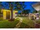 Expansive backyard with a stone path, illuminated shed, and various entertaining spaces, ideal for evening gatherings at 1543 Gentry St, Clearwater, FL 33755
