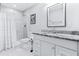 Updated bathroom features a granite vanity top, modern fixtures, and white-tiled shower at 1543 Gentry St, Clearwater, FL 33755