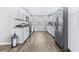 Modern white kitchen with stainless steel appliances, granite countertops, and wood-look vinyl floors at 1543 Gentry St, Clearwater, FL 33755