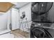 Laundry room featuring a black washer/dryer set, laminate floors, storage cabinets, and hat rack at 1543 Gentry St, Clearwater, FL 33755