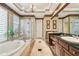 Luxurious primary bathroom with double vanity, soaking tub, and a glass enclosed shower at 1655 Eagles Reach, Tarpon Springs, FL 34688