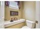 Neutral powder room featuring decorative shelf, framed picture, gold lamp and window at 1655 Eagles Reach, Tarpon Springs, FL 34688