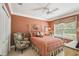 Cozy bedroom featuring a decorative chair, bed, ceiling fan, and a large window at 1655 Eagles Reach, Tarpon Springs, FL 34688