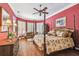 Stylish bedroom featuring a four-poster bed, hardwood floors, and shuttered windows at 1655 Eagles Reach, Tarpon Springs, FL 34688