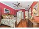 Bedroom with hardwood floors, bright red walls, and entry to primary bath at 1655 Eagles Reach, Tarpon Springs, FL 34688