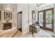Welcoming foyer with a decorative table, mirror, and elegant double doors, creating a warm and inviting entrance at 1655 Eagles Reach, Tarpon Springs, FL 34688