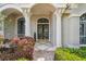 Elegant front entrance with ornate glass doors, stately columns, and lush landscaping creating a grand arrival at 1655 Eagles Reach, Tarpon Springs, FL 34688