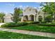 Beautiful home showcasing an inviting front yard, lush landscaping, and mature tree coverage at 1655 Eagles Reach, Tarpon Springs, FL 34688