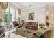 Elegant living room featuring a patterned sofa, luxurious rug, and views of the pool area at 1655 Eagles Reach, Tarpon Springs, FL 34688