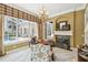 Bright home office with a fireplace, chandelier, and a large window overlooking the pool and lanai at 1655 Eagles Reach, Tarpon Springs, FL 34688