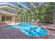 Screened pool with a spa surrounded by lush landscaping at 1655 Eagles Reach, Tarpon Springs, FL 34688