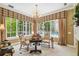 Sitting area with large windows, patterned curtains, chandelier, and backyard pool view at 1655 Eagles Reach, Tarpon Springs, FL 34688