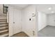 Basement hallway featuring stairs, a door to the outside, and grey tile flooring at 166 E Davis Blvd, Tampa, FL 33606