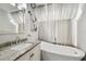 Bathroom features a modern tub, granite vanity, and sheer curtain covered window at 166 E Davis Blvd, Tampa, FL 33606