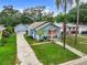 Aerial view of the home featuring a yard, driveway, and an orange front door at 2425 Auburn S St, St Petersburg, FL 33712