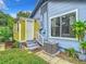 Side view of the home showing a back door, steps, AC unit, and garden at 2425 Auburn S St, St Petersburg, FL 33712