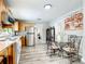 Open kitchen area with stainless steel refrigerator, dining area and wood cabinets at 2425 Auburn S St, St Petersburg, FL 33712