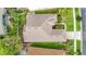 Aerial view of a well-maintained home featuring a tidy roof, manicured lawn, and vibrant landscaping at 27130 Firebush Dr, Wesley Chapel, FL 33544