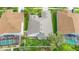 Birds-eye view of a house with a neutral roof, flourishing greenery, and screened patios at 27130 Firebush Dr, Wesley Chapel, FL 33544