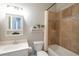 Well-lit bathroom featuring tiled shower/tub, vanity, and decor shelving over toilet at 27130 Firebush Dr, Wesley Chapel, FL 33544