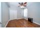 Bright bedroom with hardwood flooring, ceiling fan, closet with bi-fold doors, and window with curtain at 27130 Firebush Dr, Wesley Chapel, FL 33544