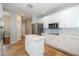 Well-lit kitchen with white cabinets, an island, and stainless steel appliances at 27130 Firebush Dr, Wesley Chapel, FL 33544