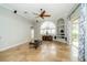 Open living room features a large arched window, travertine floors, and sliding glass doors to the lanai at 27130 Firebush Dr, Wesley Chapel, FL 33544