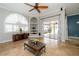 Bright living room with tile floors, a ceiling fan, and sliding glass doors to the patio at 27130 Firebush Dr, Wesley Chapel, FL 33544