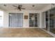 Covered patio with travertine flooring, ceiling fan, and sliding glass doors offering indoor/outdoor living at 27130 Firebush Dr, Wesley Chapel, FL 33544