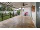 Covered travertine patio featuring landscaped garden view with black iron fence and retractable awning at 27130 Firebush Dr, Wesley Chapel, FL 33544