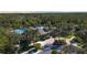 Aerial view of a community pool with palm trees, a slide, and lush landscaping creating a resort-like setting at 27130 Firebush Dr, Wesley Chapel, FL 33544