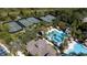 Aerial view of community pool, slide, and tennis courts surrounded by trees showcasing recreational amenities at 27130 Firebush Dr, Wesley Chapel, FL 33544