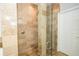 Walk-in shower with travertine tile and glass door showcasing quality craftsmanship at 27130 Firebush Dr, Wesley Chapel, FL 33544