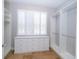 Spacious walk-in closet with custom shelving, built-in drawers, and a window with white shutters at 27130 Firebush Dr, Wesley Chapel, FL 33544