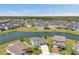 Wide aerial shot displays a lakeside neighborhood with many homes and lush greenery in the background at 28683 Lucero Ln, Wesley Chapel, FL 33543