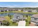 Aerial view of a two-story home with a three-car garage and a lake view at 28683 Lucero Ln, Wesley Chapel, FL 33543