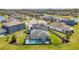 Aerial shot of a well-maintained home with a screened pool, set in a lush community with lake views at 28683 Lucero Ln, Wesley Chapel, FL 33543