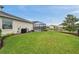 Beautifully landscaped backyard with a screened-in pool, lush lawn, and tranquil water view at 28683 Lucero Ln, Wesley Chapel, FL 33543