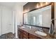 Modern bathroom featuring a double sink vanity with granite countertops and a large framed mirror at 28683 Lucero Ln, Wesley Chapel, FL 33543