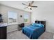 Bright bedroom with ceiling fan, two windows, carpeted floors and study desk with black chair at 28683 Lucero Ln, Wesley Chapel, FL 33543