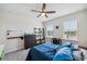 Bright bedroom with ceiling fan, two windows, carpeted floors and study desk with black chair at 28683 Lucero Ln, Wesley Chapel, FL 33543