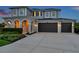 Charming two-story home featuring a three-car garage, arched entryway, and meticulously landscaped front yard at 28683 Lucero Ln, Wesley Chapel, FL 33543