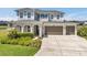 Spacious home featuring a three-car garage, well-manicured lawn, and covered front entry at 28683 Lucero Ln, Wesley Chapel, FL 33543