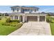 Spacious home featuring a three-car garage, well-manicured lawn, and covered front entry at 28683 Lucero Ln, Wesley Chapel, FL 33543