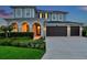 Charming two-story home featuring a three-car garage, arched entryway, and meticulously landscaped front yard at 28683 Lucero Ln, Wesley Chapel, FL 33543