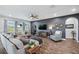 Spacious living room with dark accent wall, large windows, wood-look flooring and comfortable seating at 28683 Lucero Ln, Wesley Chapel, FL 33543